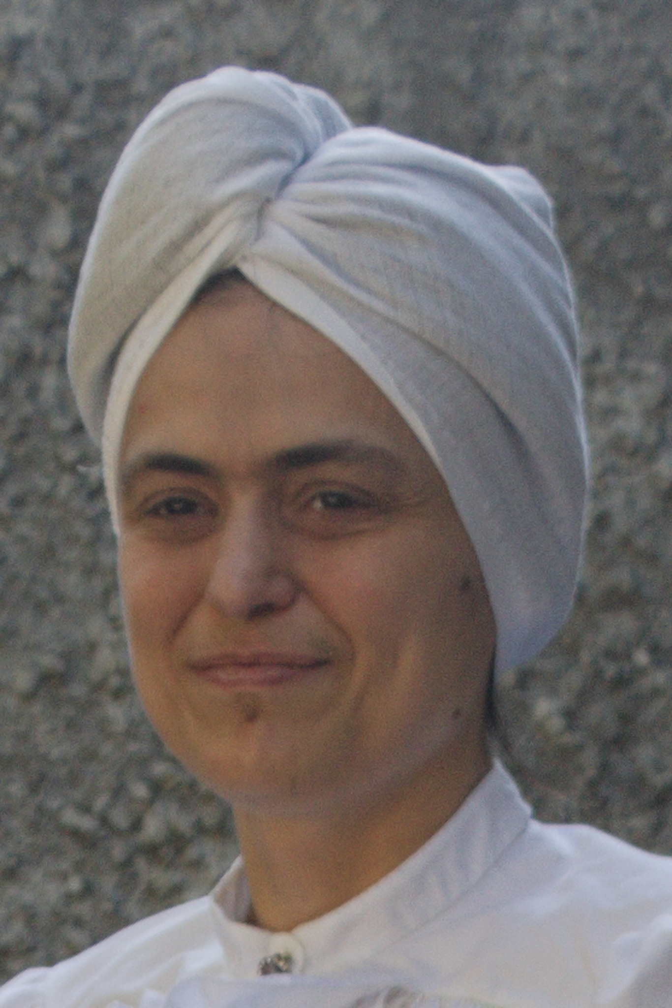 The head of a woman with a turban-like thing on the head,
covering all of the hair except for a tiny bit at the center
front.