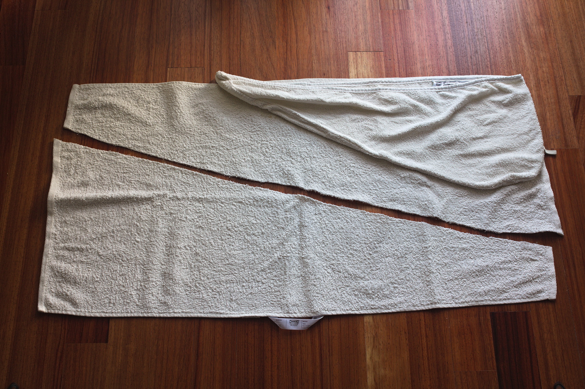 A towel cut in two trapezoid halves with a STJÄRNBUSKE laid on
top of it: the IKEA wrap is a bit less than 10 cm less deep, and
at least 30 cm shorter, and is also triangular rather than a
trapezoid.