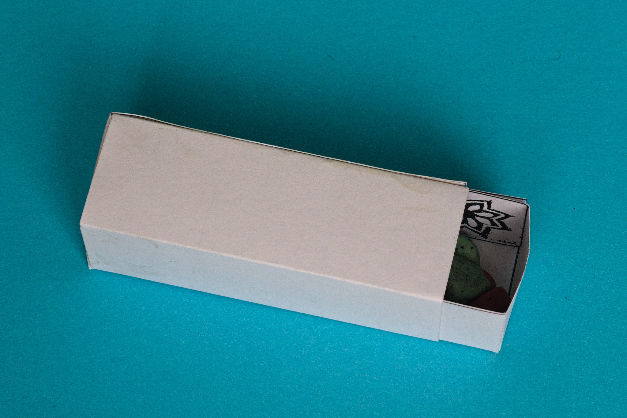 A white box, about 2.5 cm   2.5 cm   7.5 cm; a drawer is sliding out of one small end.