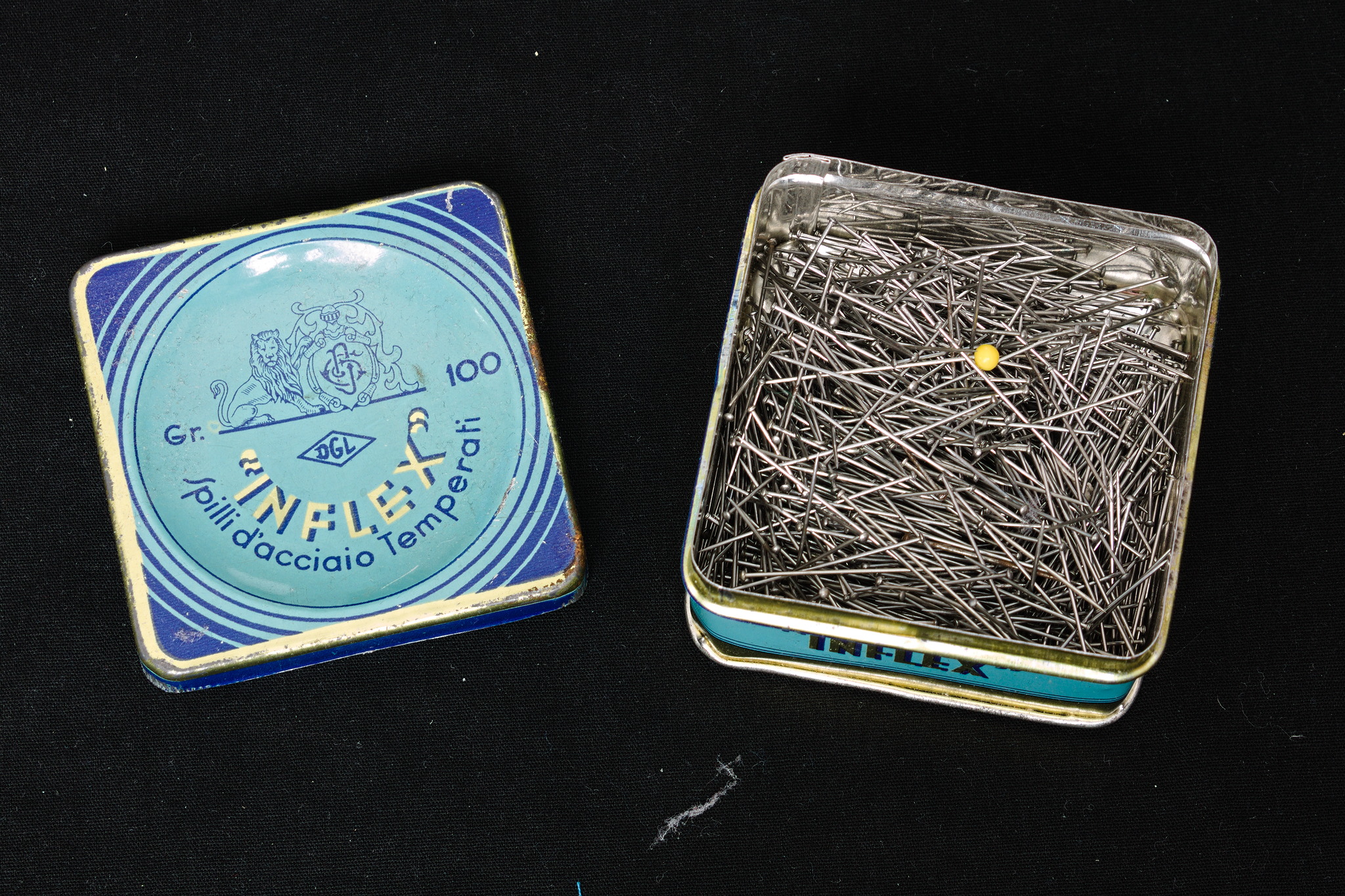 A metal box full of straight pins.