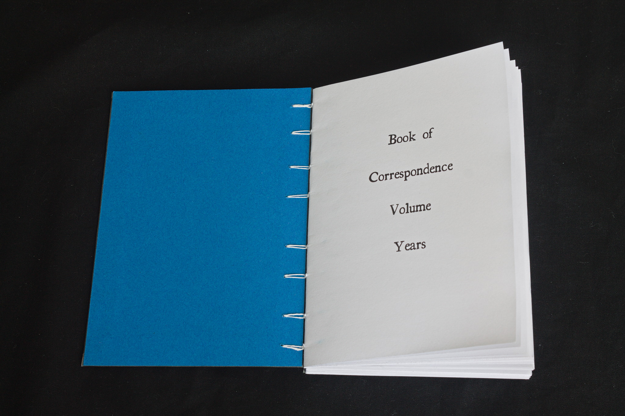 A Coptic bound book open to the first page with the title  Book of <space> Correspondence / Volume <space> Years <space> 
