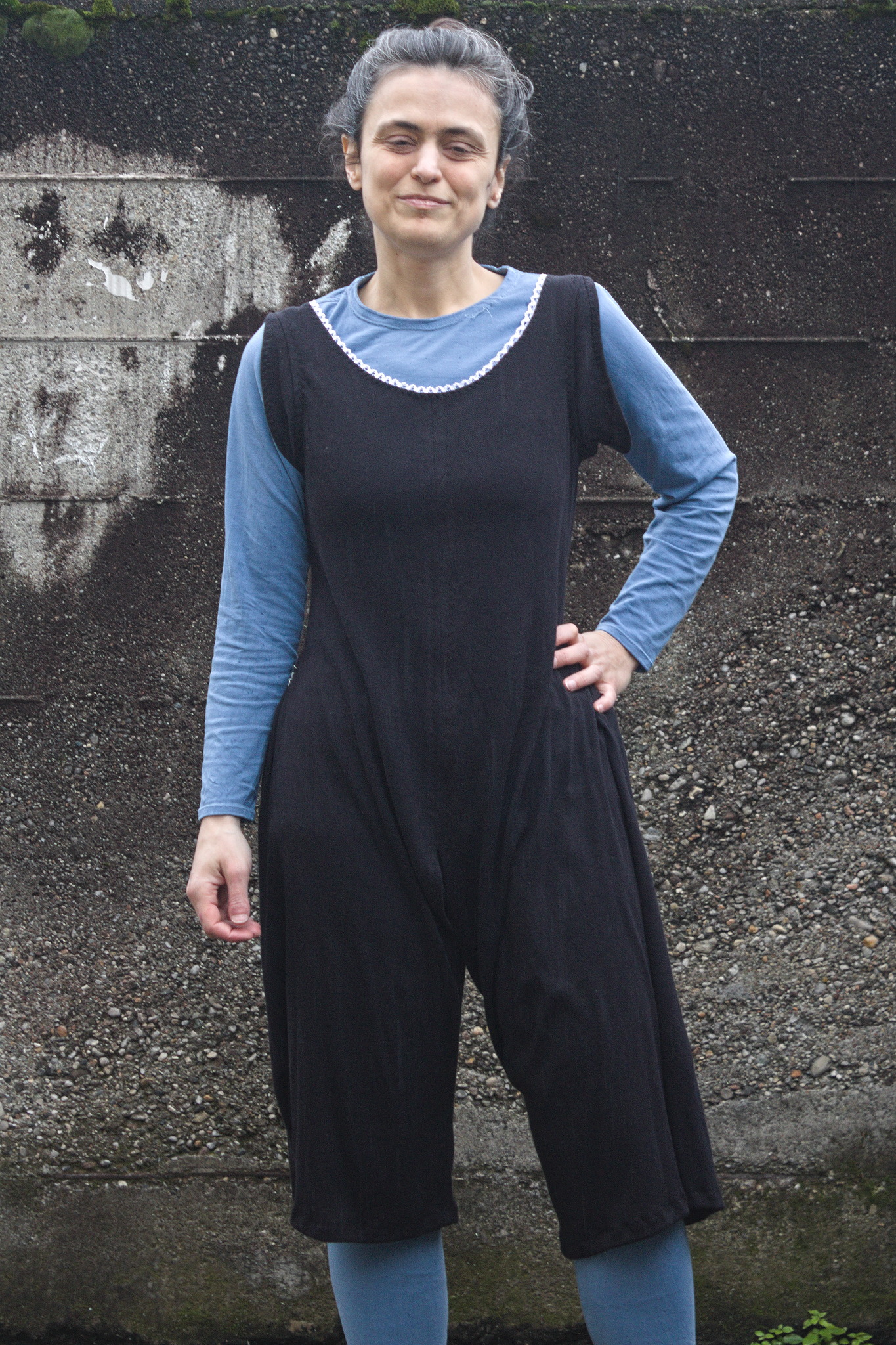 a woman wearing a black cotton jersey combination suite; the front is sewn shut, but the neck is wide and finished with elastic.  The top part is pretty fitted, but becomes baggier around the crotch area and the legs are a comfortable width.