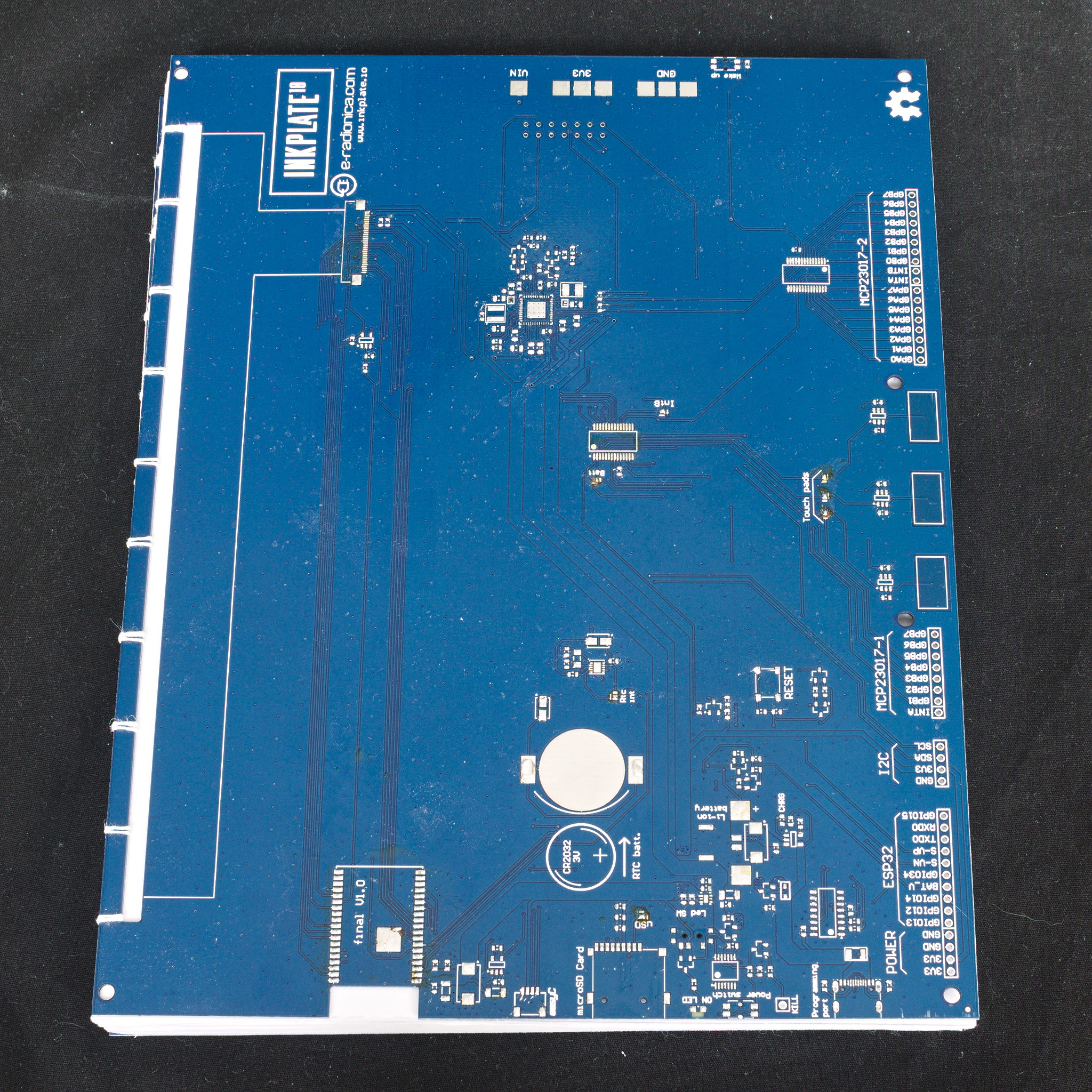 A coptic bound book with a blue PCB as the cover.