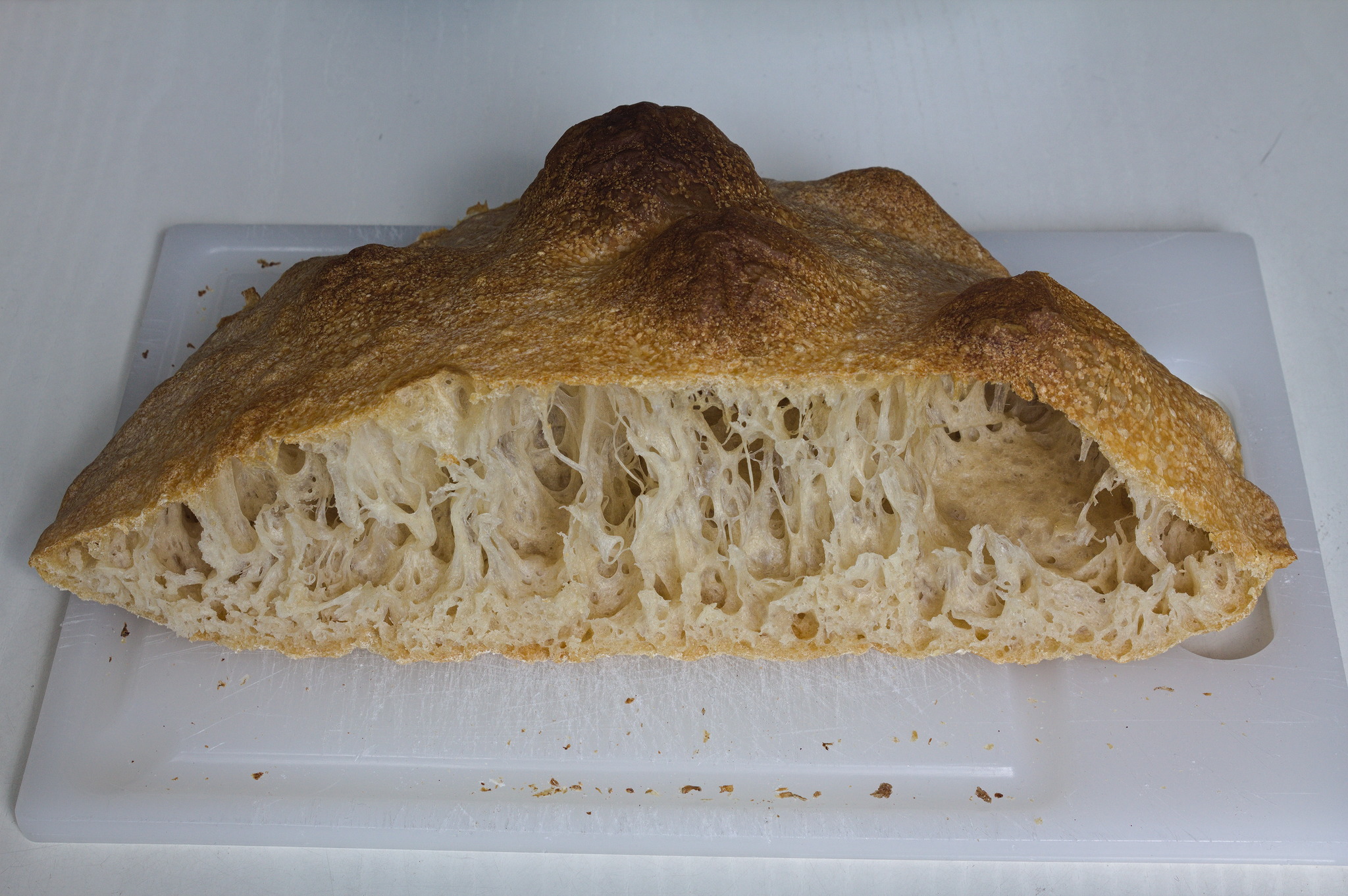 the loaf cut in half, to show thin stripes of crumb from the
high hydration.