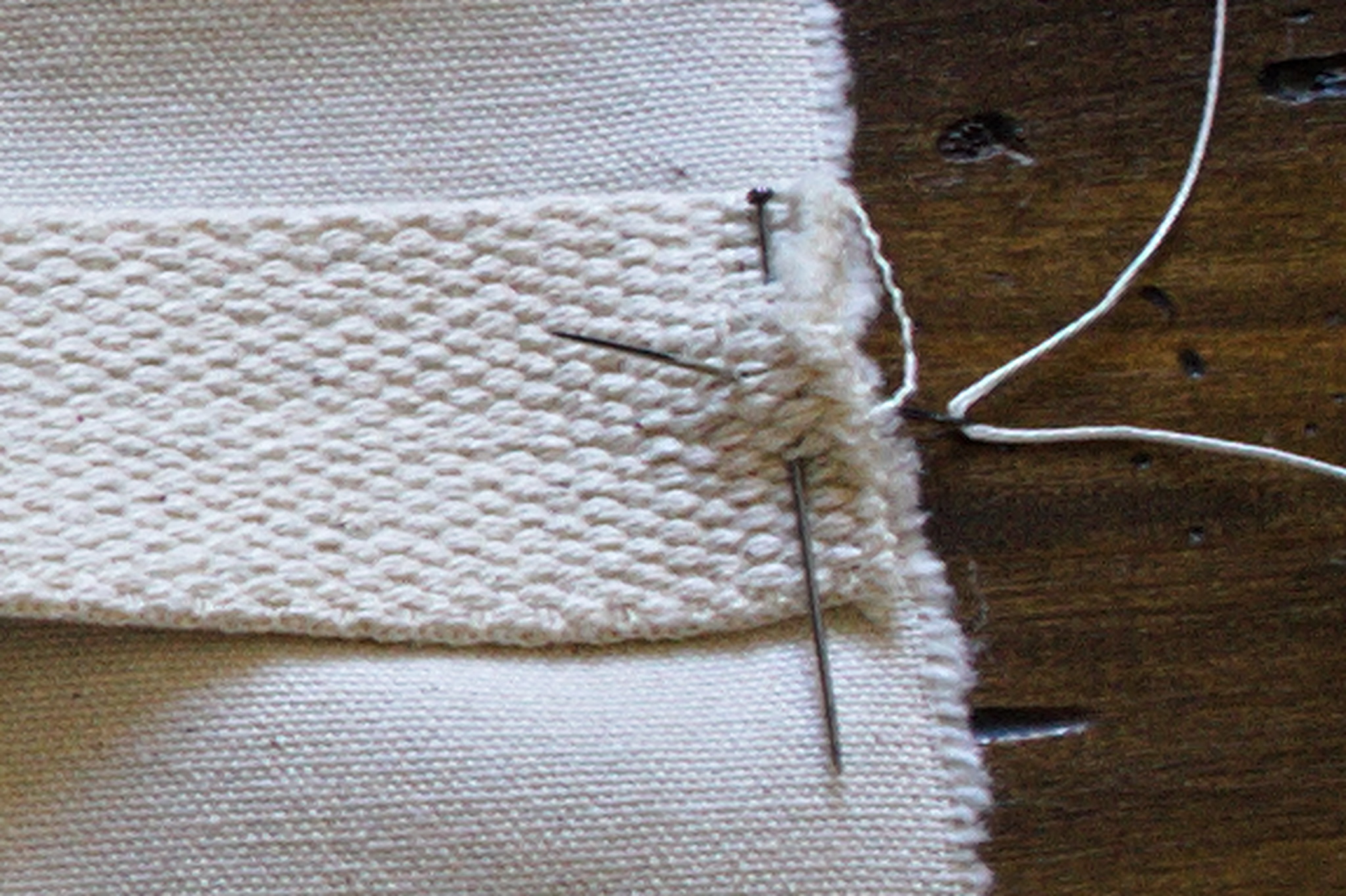 a needle coming straight up through layers of fabric and
webbing, in the motion called stabbing.