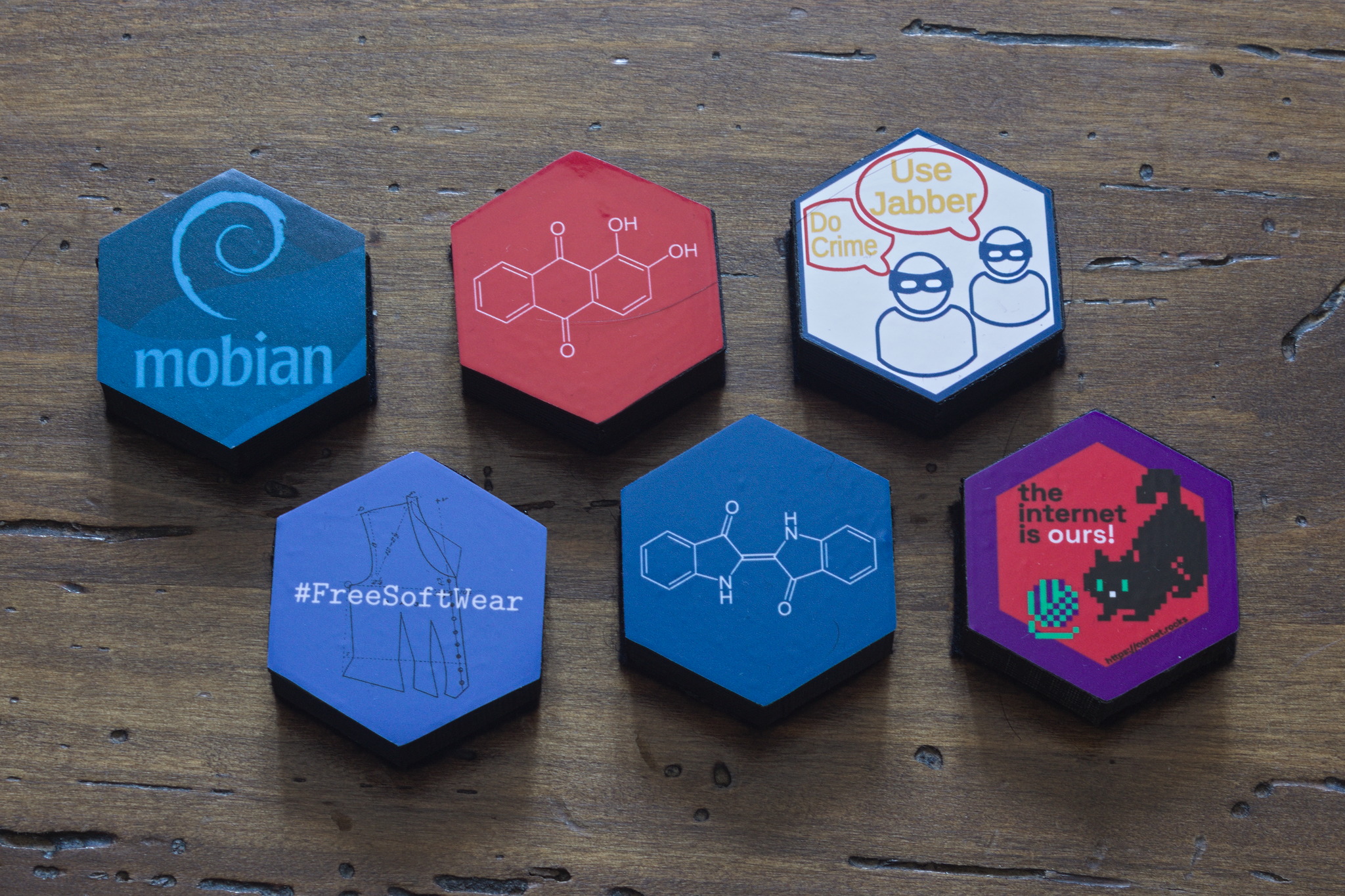 Six hexagonal blocks with a Standard Compliant sticker on top:
mobian (blue variant), alizarin molecule, Use Jabber / Do Crime,
#FreeSoftWear, indigotin molecule, The internet is ours with a
cat that plays with yarn.