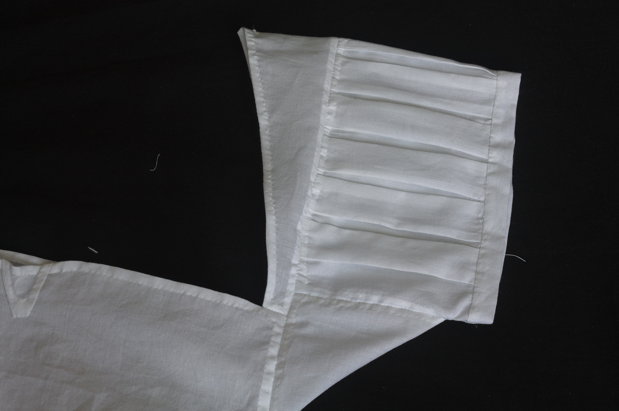 Sleeve detail, showing box pleats that are about 2 cm wide and
a few mm distance from each other all along the circumference,
neatly sewn into the shoulder strap on one side and the band at
the other side.