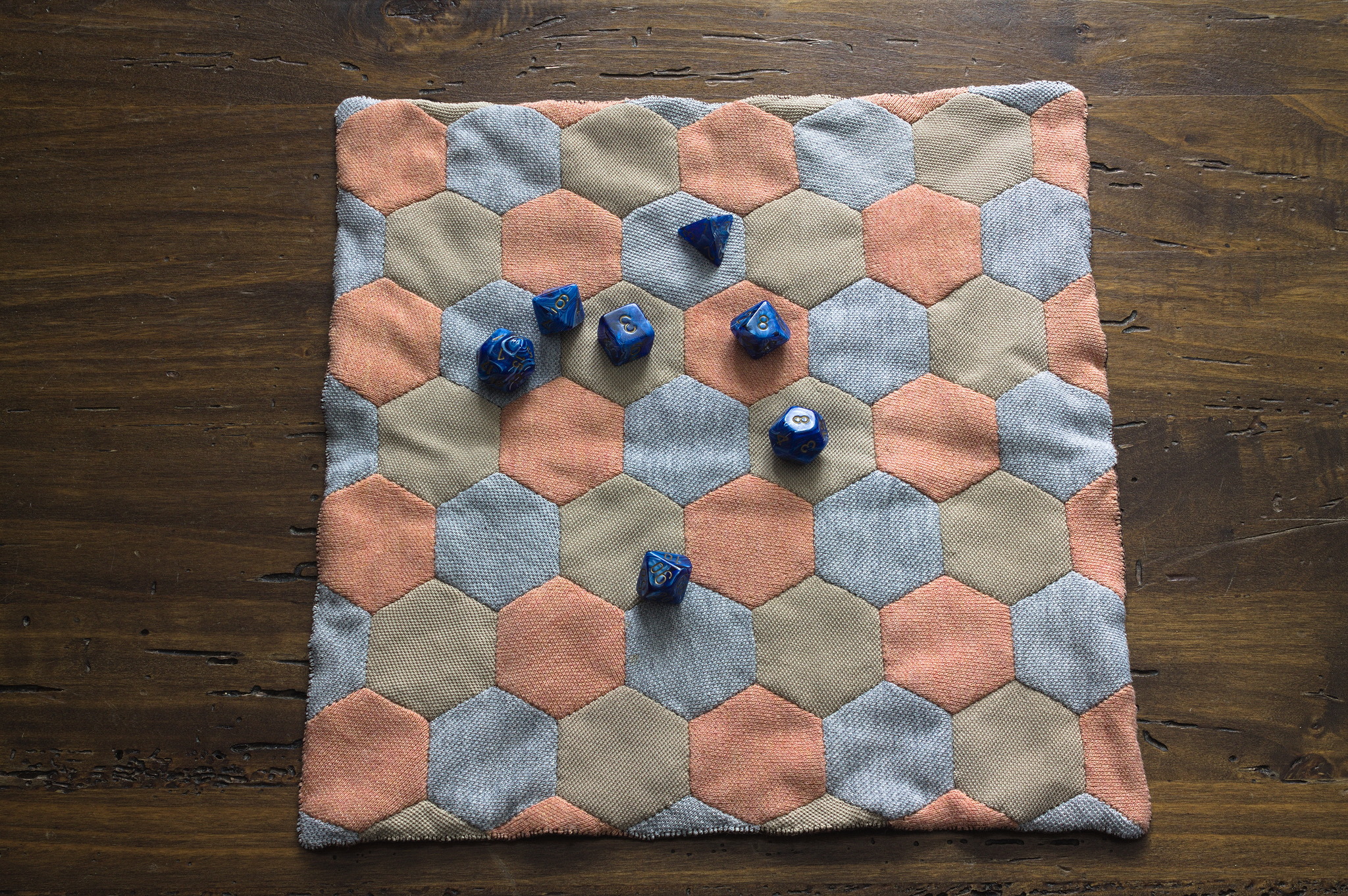 The hexagon side of the mat, with a set of polyhedral dice.