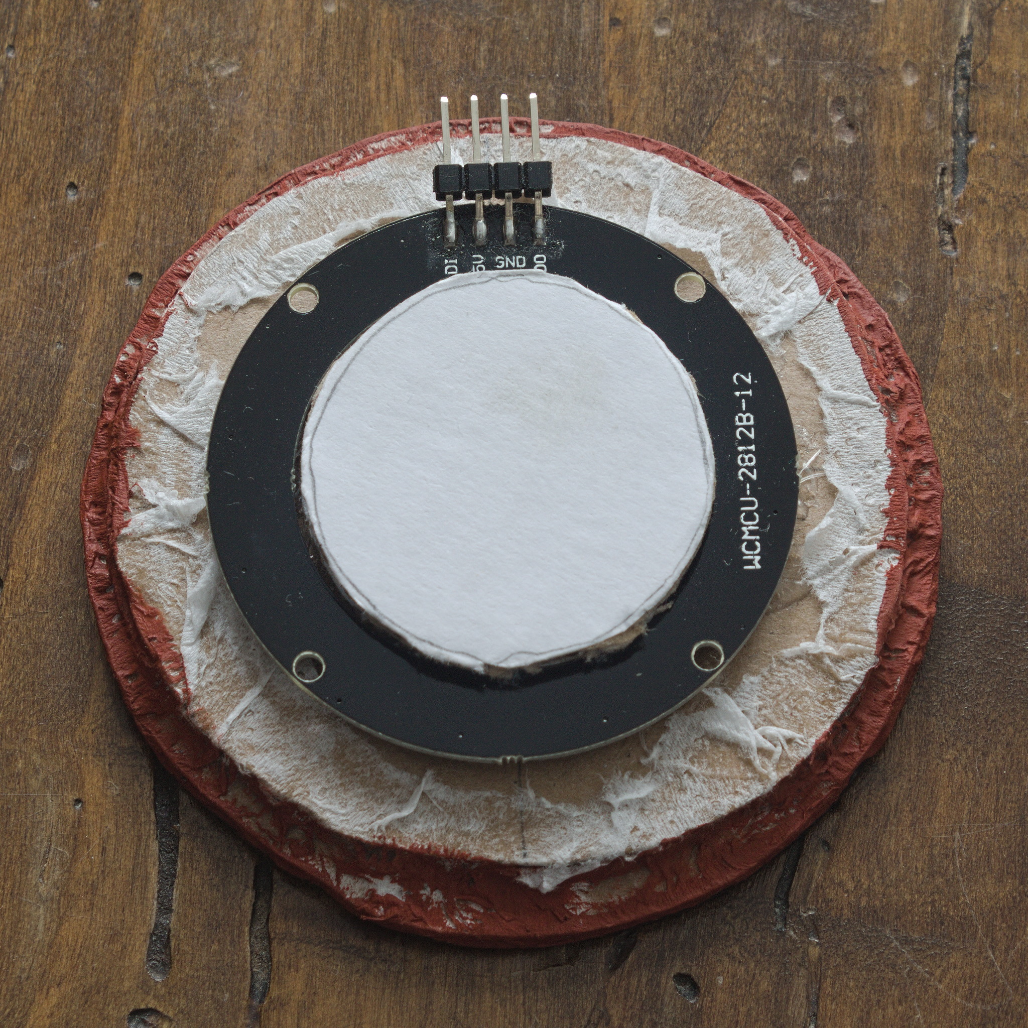 a structure made of circles of cardboard in various sizes glued
together and strengthened with tissue paper, with a LED ring
fitting snugly on top. The ring is marked WCMCU-2812B-12.