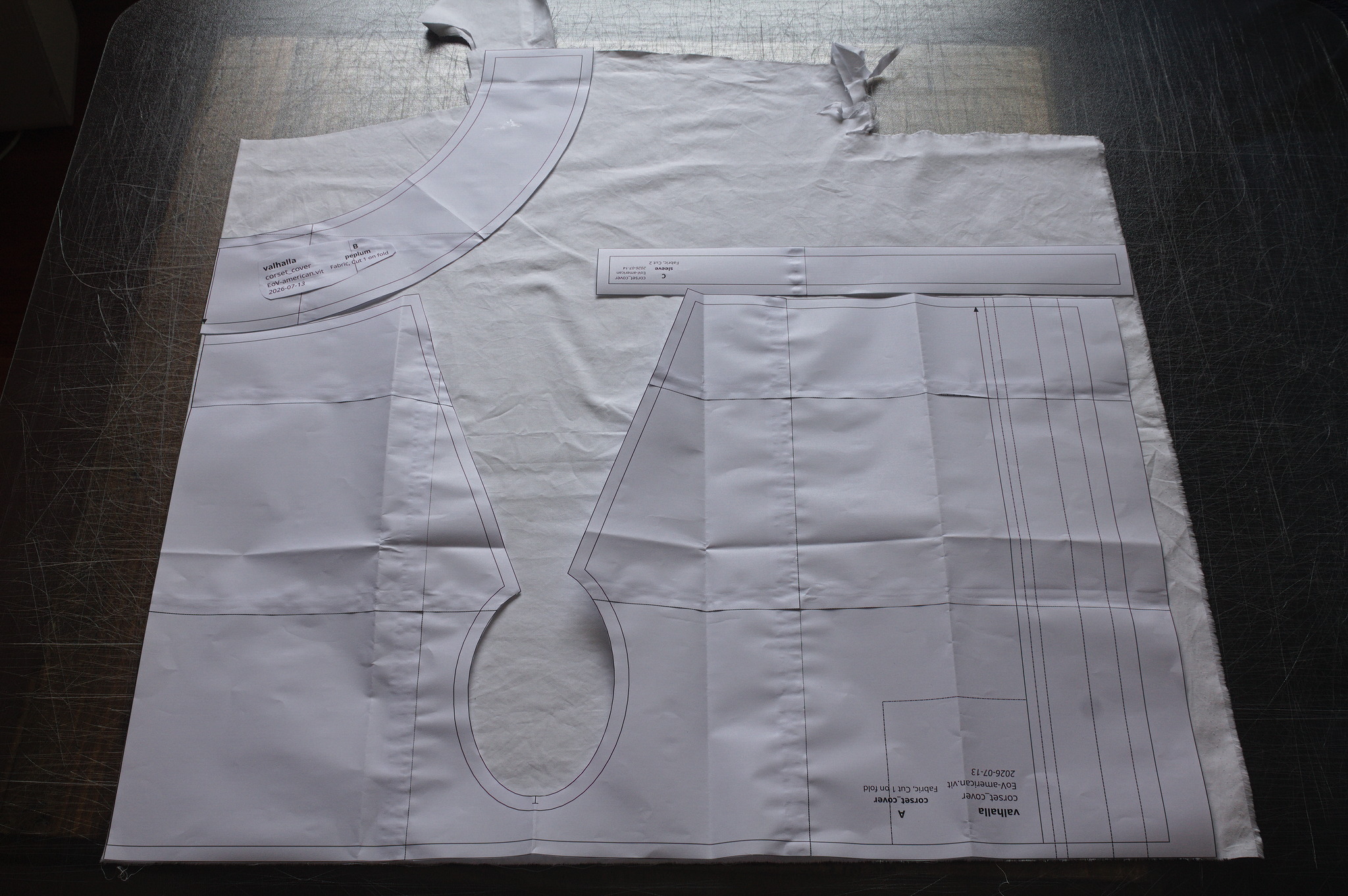 The corset cover pattern laid on fabric: just wide enough for
the main piece, and the peplum only fit because the fabric
leftover was in the exact right shape for it to lie on the fold in
one specific position.